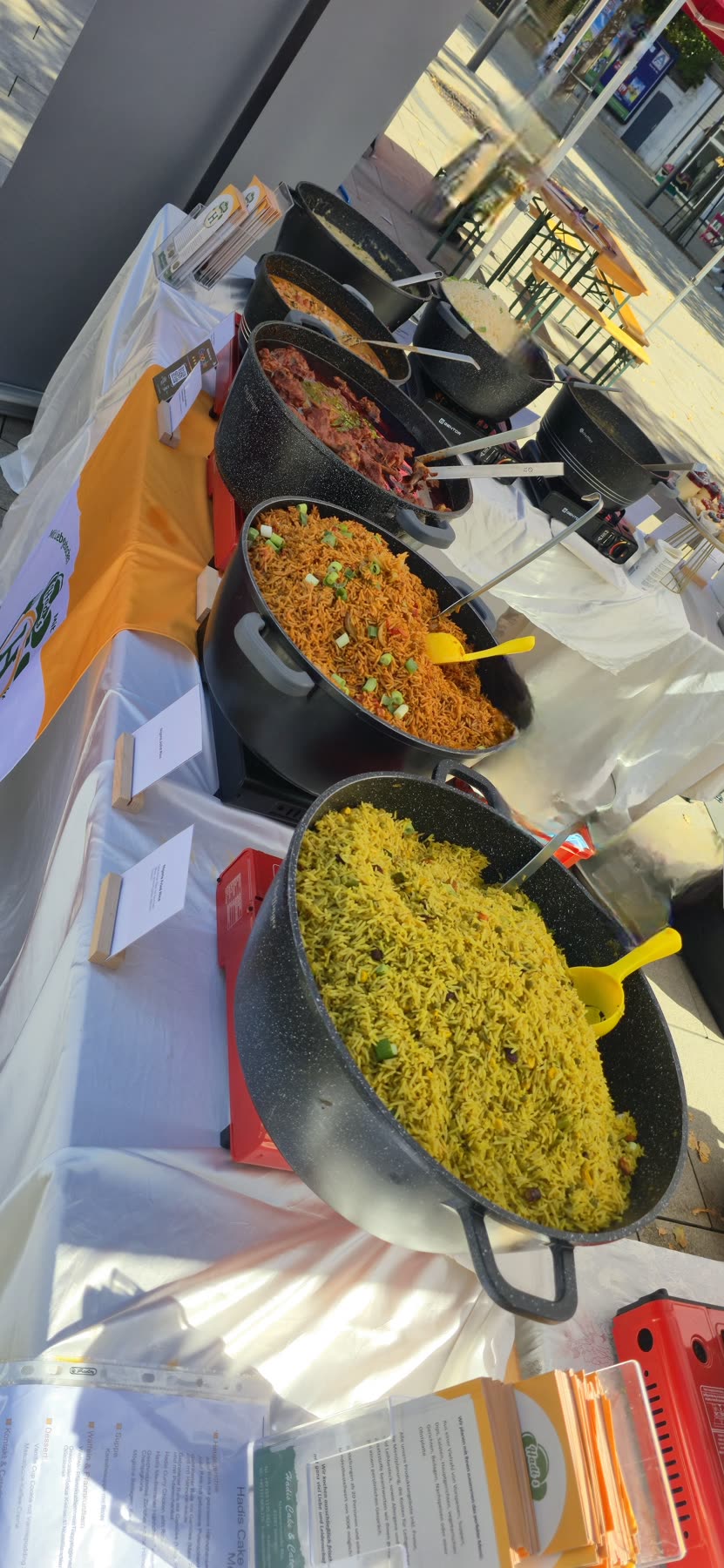 Große Pfannen mit Jollof Rice und Fried Rice bei einem Catering-Einsatz