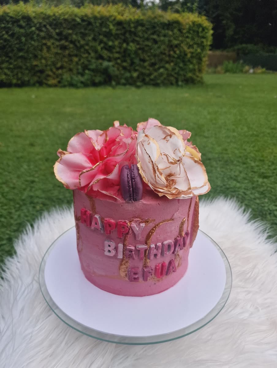 Rosa Torte mit großen Zuckerblüten im Garten