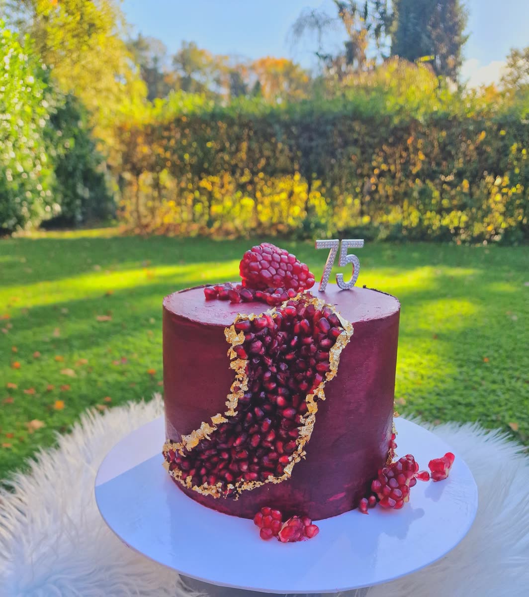 Rote Torte mit Granatapfel und Zahl 75